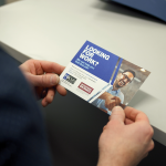 A man reads a leaflet containing info on Focus programs.